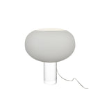 The grey version of this Clérachic table lamp, a wide frosted globe on a clear glass cylinder, with its clear cord curling to the right.