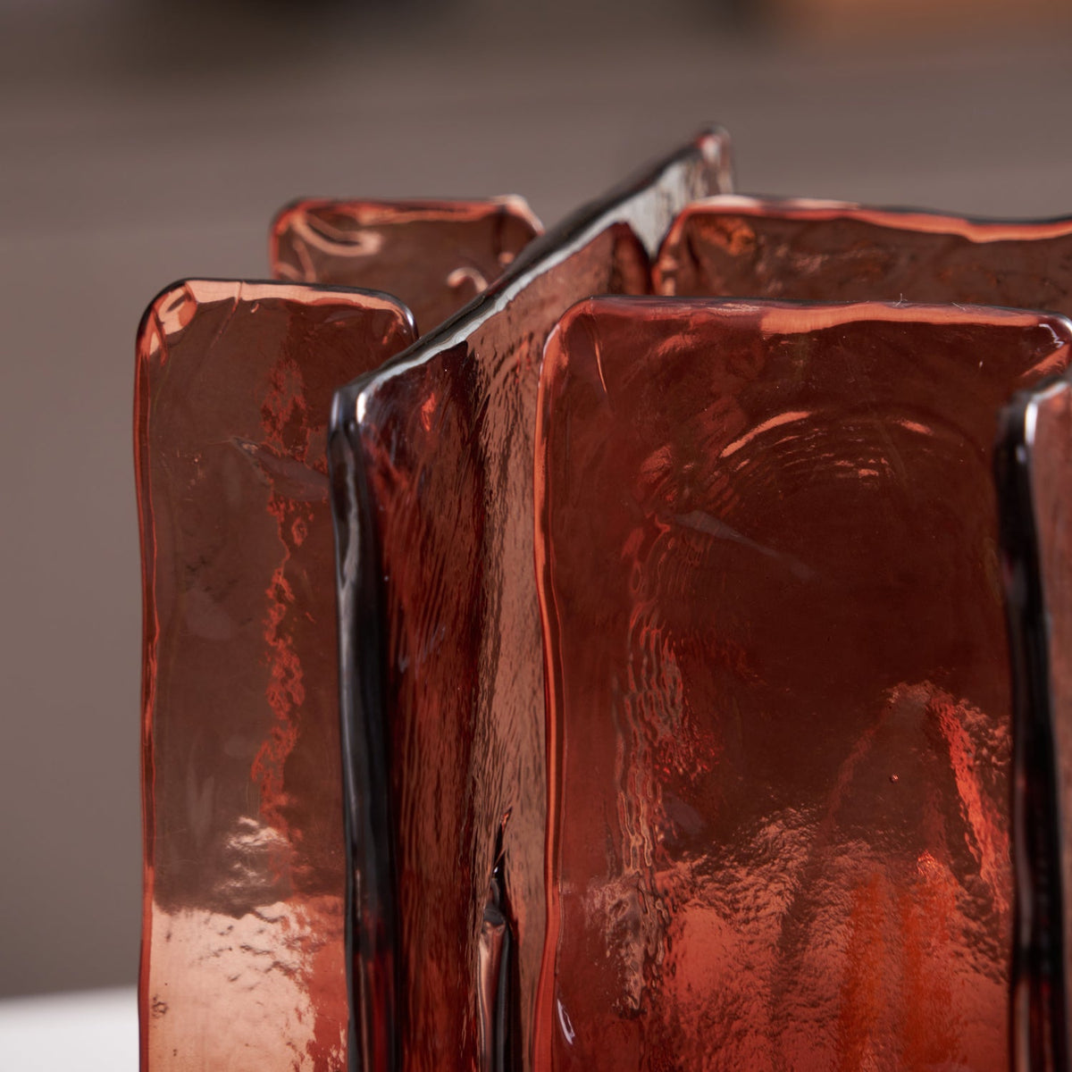 Close view of the hand-poured texture and dark-edged seams of the amber-red glass panels on this Clérachic table lamp.