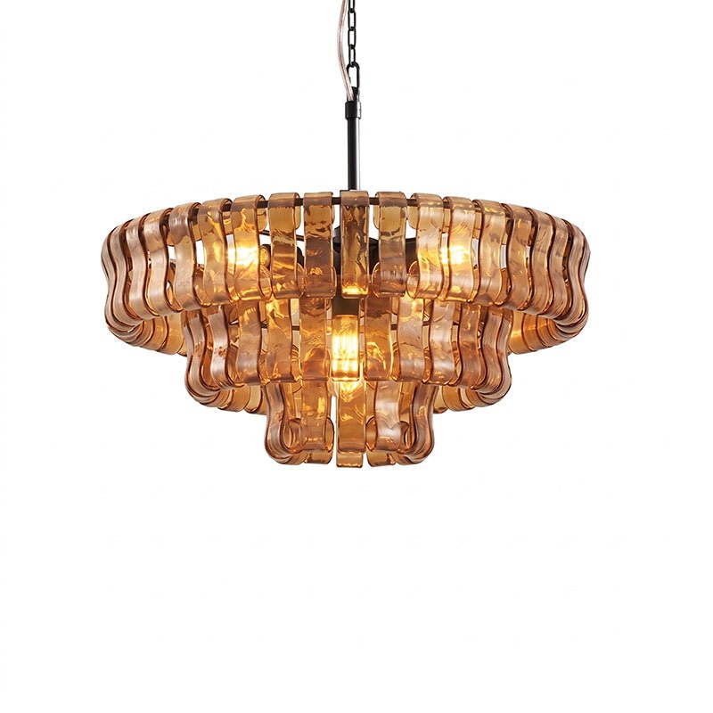Warm amber glass tiers and a brass stem on this Clérachic chandelier, lit at the centre, on a white background.