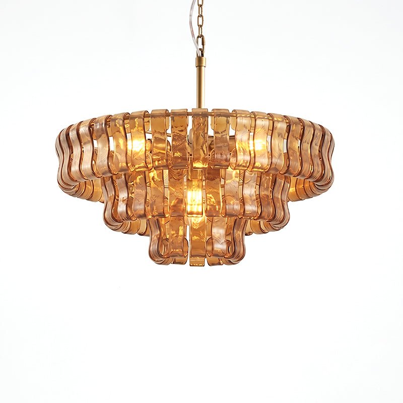 Peach-amber glass Clérachic chandelier with three tiers and warm bulbs lit inside, on a white background.