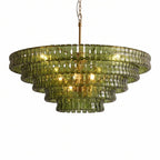 Olive-green glass Clérachic chandelier with five stepped tiers and a brass stem, lit warm inside, on white.