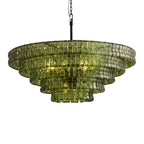 Wide and flat in shape, this green glass Clérachic chandelier has five tiers on a black stem, shown on white.