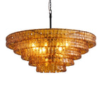 Orange bulbs glow through the five stepped amber tiers of this Clérachic chandelier, hung on a black stem and chain.