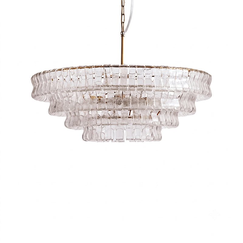 Clear glass tiers with a pale gold rim on this Clérachic chandelier, with a brass stem, on white.