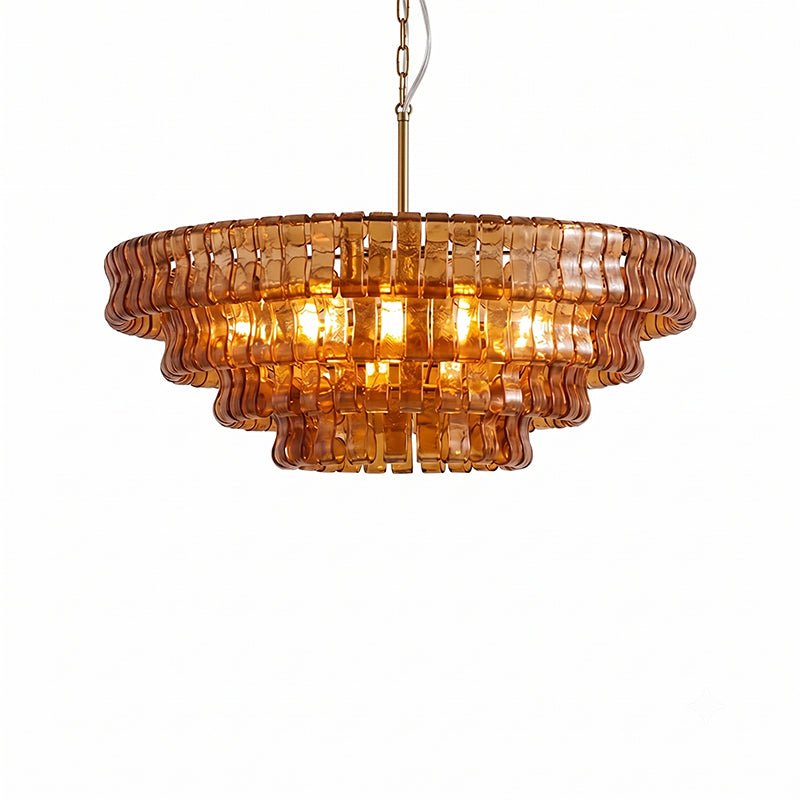 Orange-amber glass on this Clérachic chandelier is lit brightly inside, hung from a brass stem on a white backdrop.