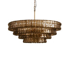 Dark bronze glass tiers of this Clérachic chandelier, unlit, hung on a brass stem against white.