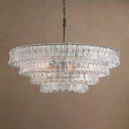 Clear glass tiers on this Clérachic chandelier, with a black chain, softly lit against a taupe backdrop.