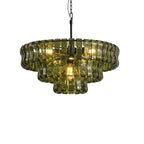 Lit from within, this three-tier green glass chandelier from Clérachic hangs on a black stem against white.
