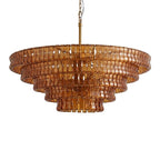 Warm amber-brown glass and a brass stem on this Clérachic chandelier, with five wide tiers, on a white backdrop.