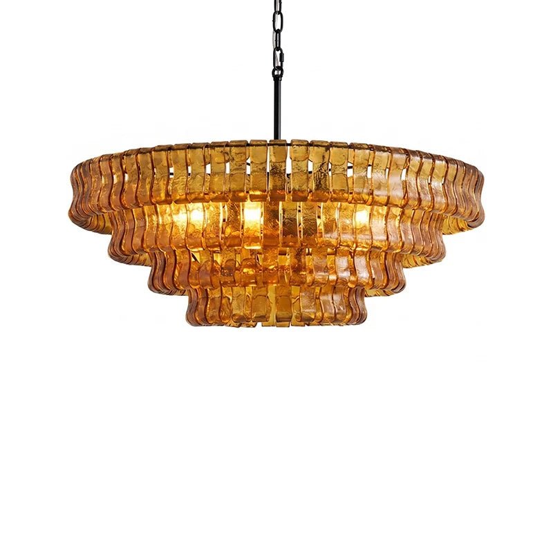 Warm bulbs glow through four stepped amber tiers on this Clérachic chandelier with a black stem, on white.