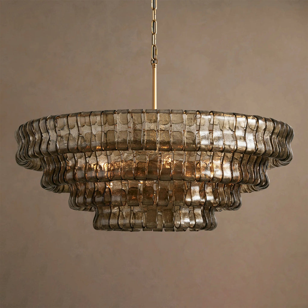 Smoke-grey glass and soft reflections on this Clérachic chandelier, five tiers on a brass stem against a taupe backdrop.