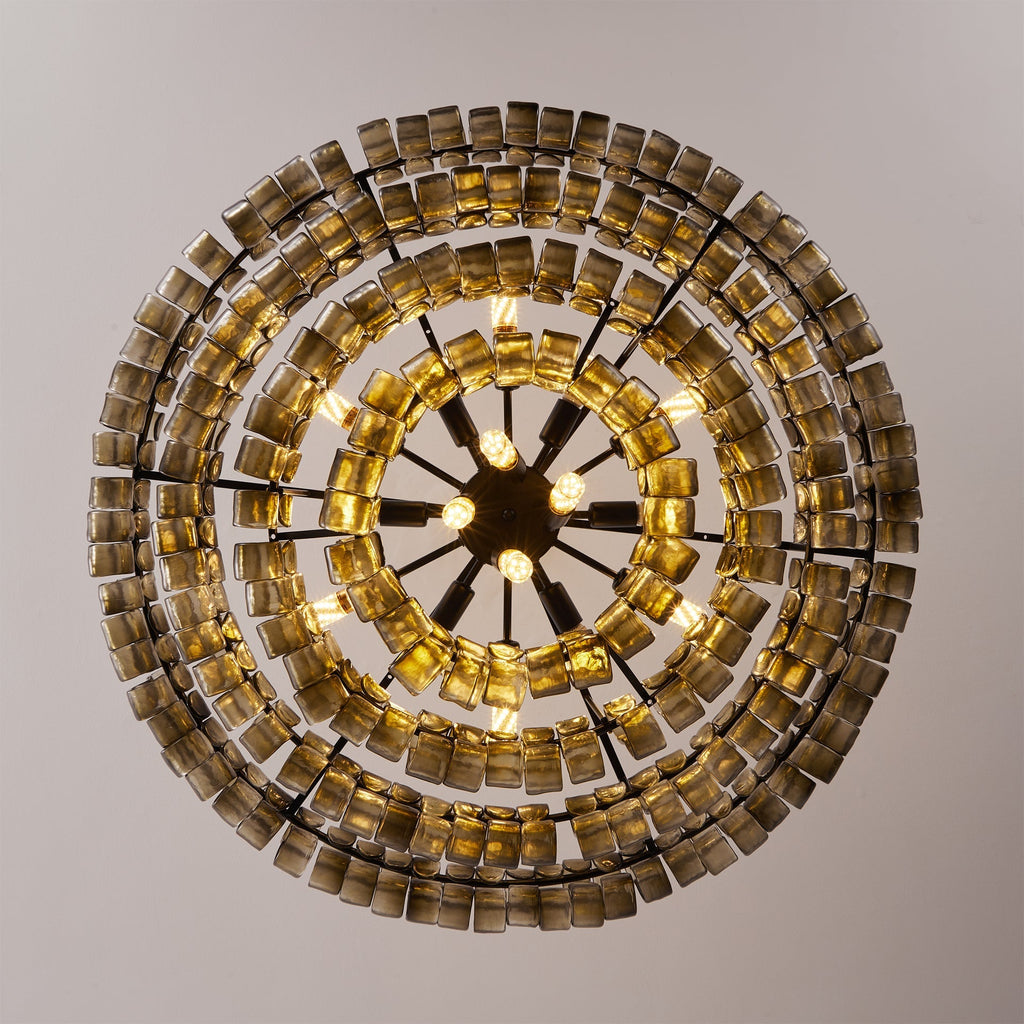 Looking straight up at a Clérachic chandelier, concentric rings of smoke-grey glass tiles circle a black spoked hub with bulbs.