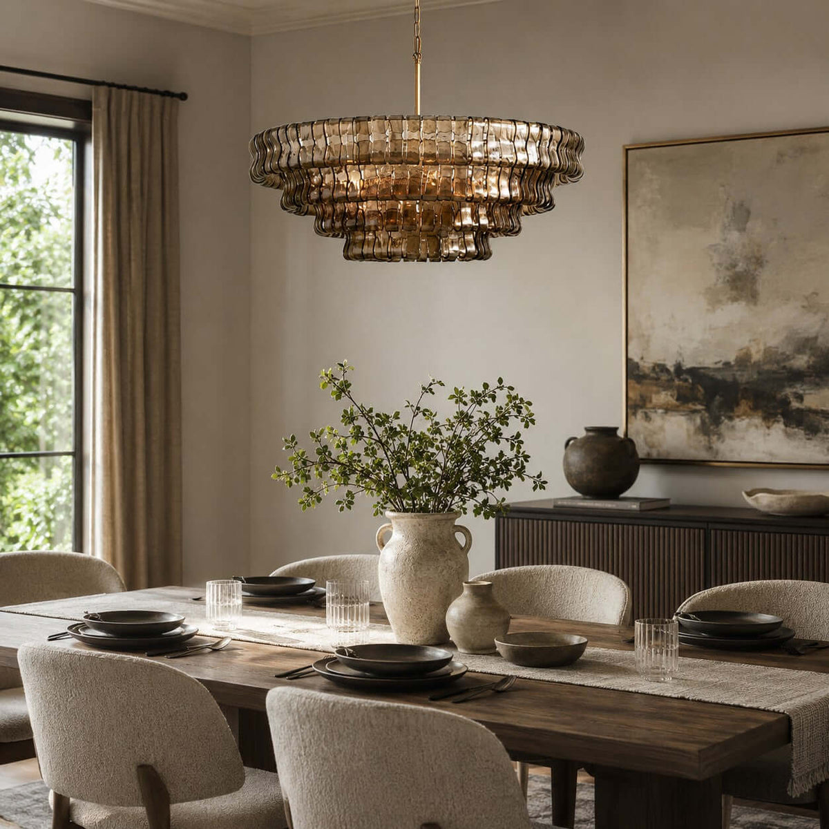 Above a dark wood dining table with cream chairs and a pale vase, a smoke-grey Clérachic chandelier hangs in a bright room.