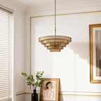 In a bright room with white panelling and gold trim, a champagne glass Clérachic chandelier hangs near a framed picture.