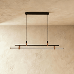 Clérachic black linear pendant switched off, its opal tube held by tan straps beneath a thin bar and an oval canopy.