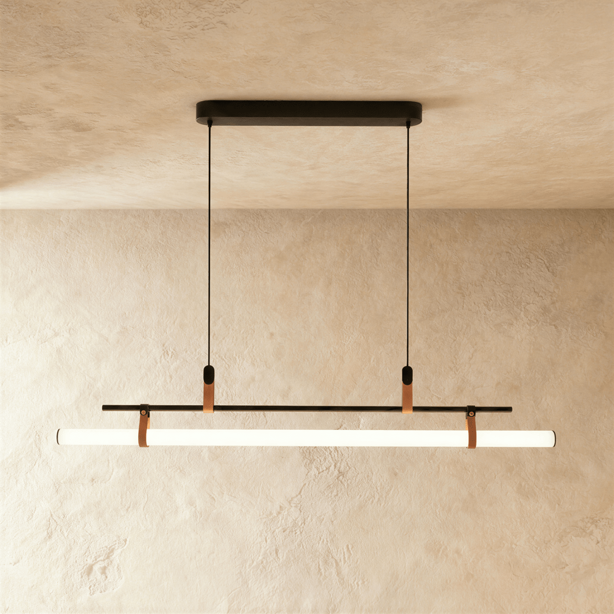 Clérachic longer black linear pendant, a lit opal tube strapped under a slim bar and hung from two cords on a plaster wall.