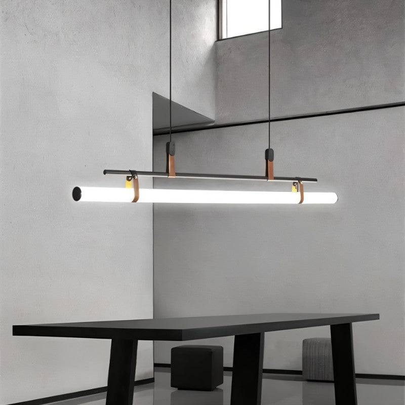 Clérachic black linear pendant with a bright opal tube over a black table in a concrete-walled room with a high window.