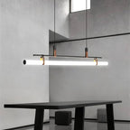 Clérachic black linear pendant with a bright opal tube over a black table in a concrete-walled room with a high window.