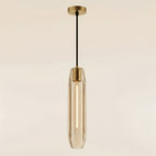 Clérachic glass tube pendant in champagne-tinted clear glass, lit so each vertical facet reads as a bright flute beneath its brass collar and ceiling plate