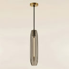 The same pendant in smoked grey glass, the warm LED inside reading softly through the tinted facets
