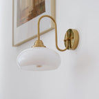 Clérachic glass wall lamp, copper arm and white glass, hardwired beside a pale framed print.