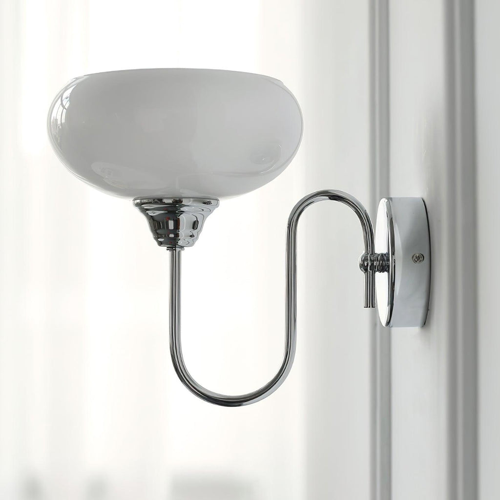 Clérachic glass wall lamp in chrome with white glass, hardwired on a wall with vertical paneling.