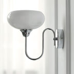 Clérachic glass wall lamp in chrome with white glass, hardwired on a wall with vertical paneling.