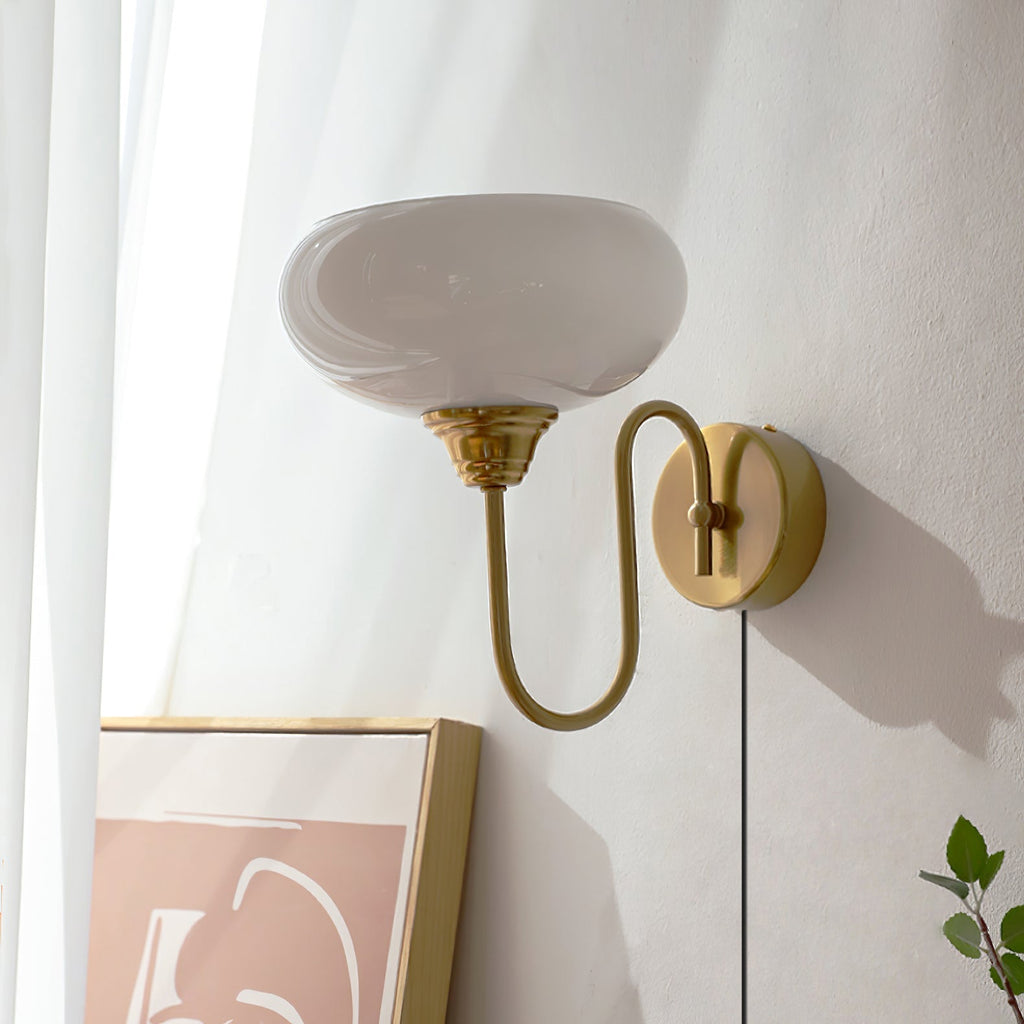 Clérachic glass wall lamp in copper with white glass and a plug-in cord above a gold-framed print.