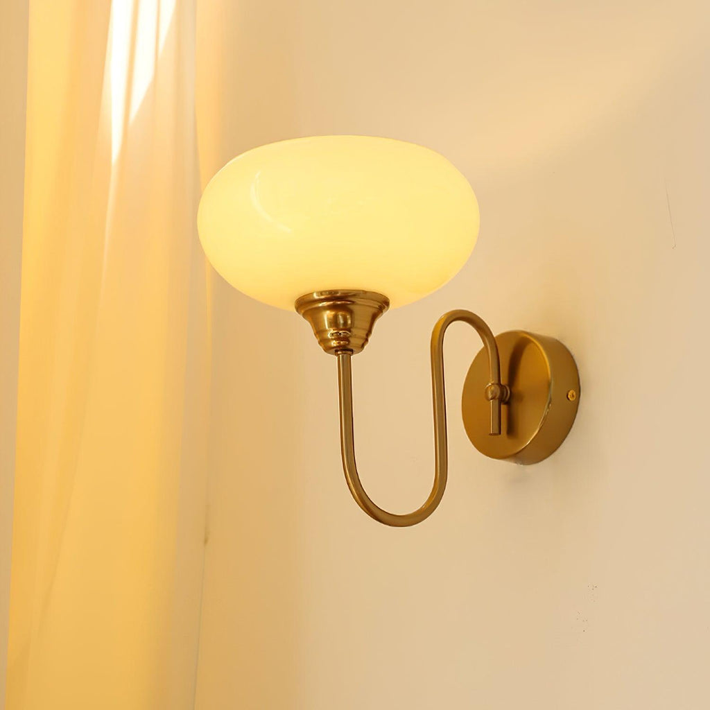Clérachic glass wall lamp in copper with a glowing beige shade, hardwired beside a cream curtain.
