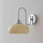 Clérachic glass wall lamp in chrome with an unlit beige dome, hardwired on a light grey studio backdrop.