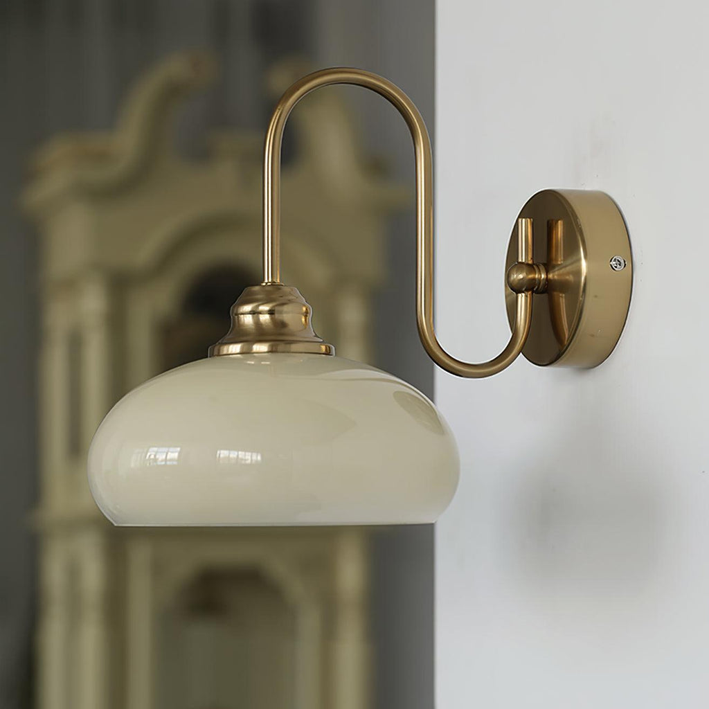Clérachic glass wall lamp, copper arm and beige glass, hardwired beside a carved wood cabinet.