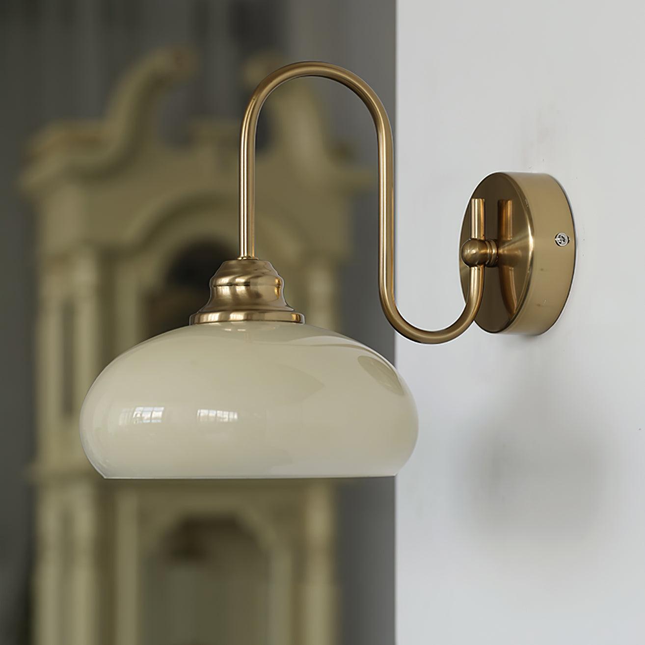 Clérachic glass wall lamp, copper arm and beige glass, hardwired beside a carved wood cabinet.