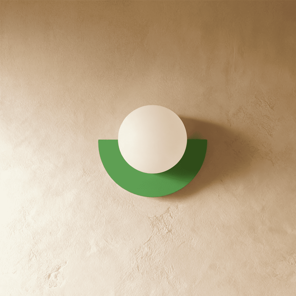 Clérachic opal glass globe on a green half-moon metal back plate, switched off, on a warm limewash plaster wall.