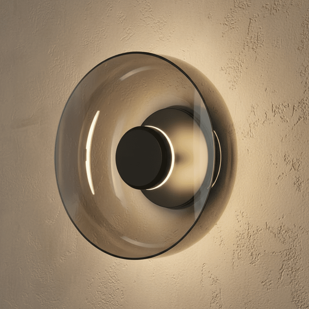 Clérachic glass uplight wall bowl in Smoky gray, its tinted dome glowing warm around a black centre knob.