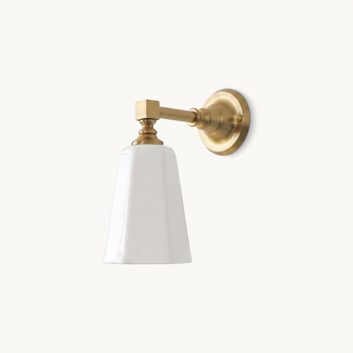 Gold finish Clérachic wall sconce on a plain white backdrop, with a tapered white glass shade, square-cornered arm and round backplate.