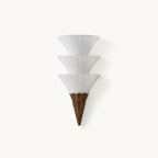 Unlit Clérachic wall sconce with three stacked frosted glass cones and a bronze-brown base, on a white backdrop.