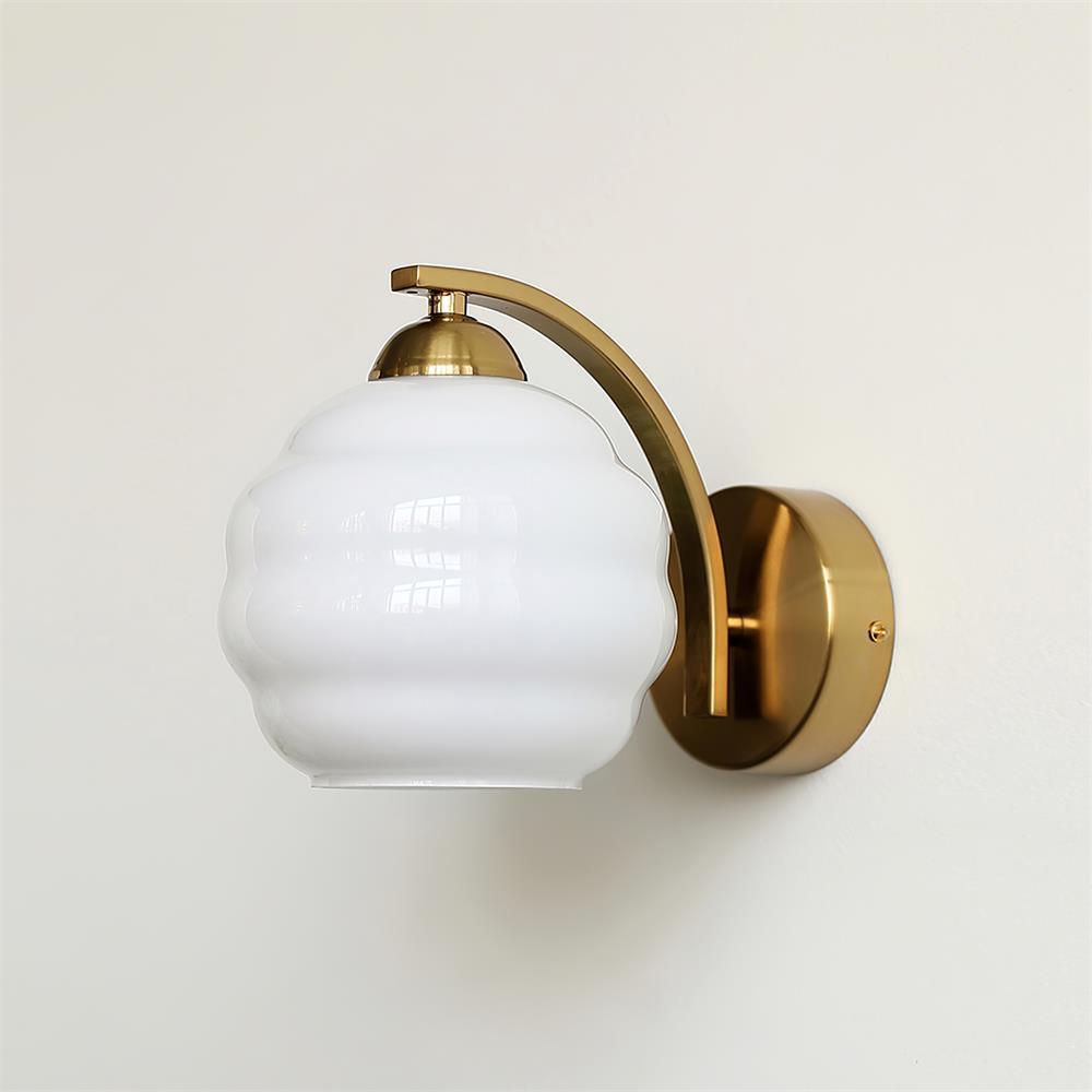 Side profile of the Clérachic glass wall sconce in gold, its white lantern shade hanging from the arched arm.