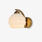 Clérachic gold wall sconce lit in the studio, warm light filling the white ribbed lantern shade.