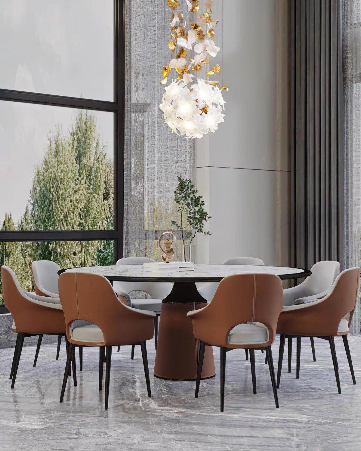 Over a round marble dining table with tan leather chairs, a small round Clérachic chandelier of white petals hangs near a tall window.