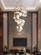 Hung in a tall panelled living room above a television, this Clérachic chandelier winds down in a slender S of white petals and brass.