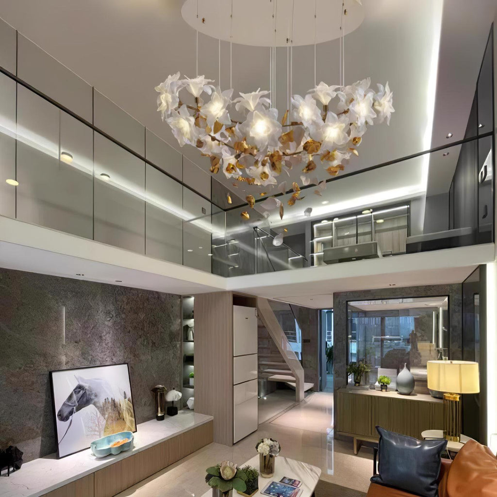 Spread wide beneath a white ceiling, this Clérachic chandelier hangs in a double-height living room with a glass balcony and sideboard.
