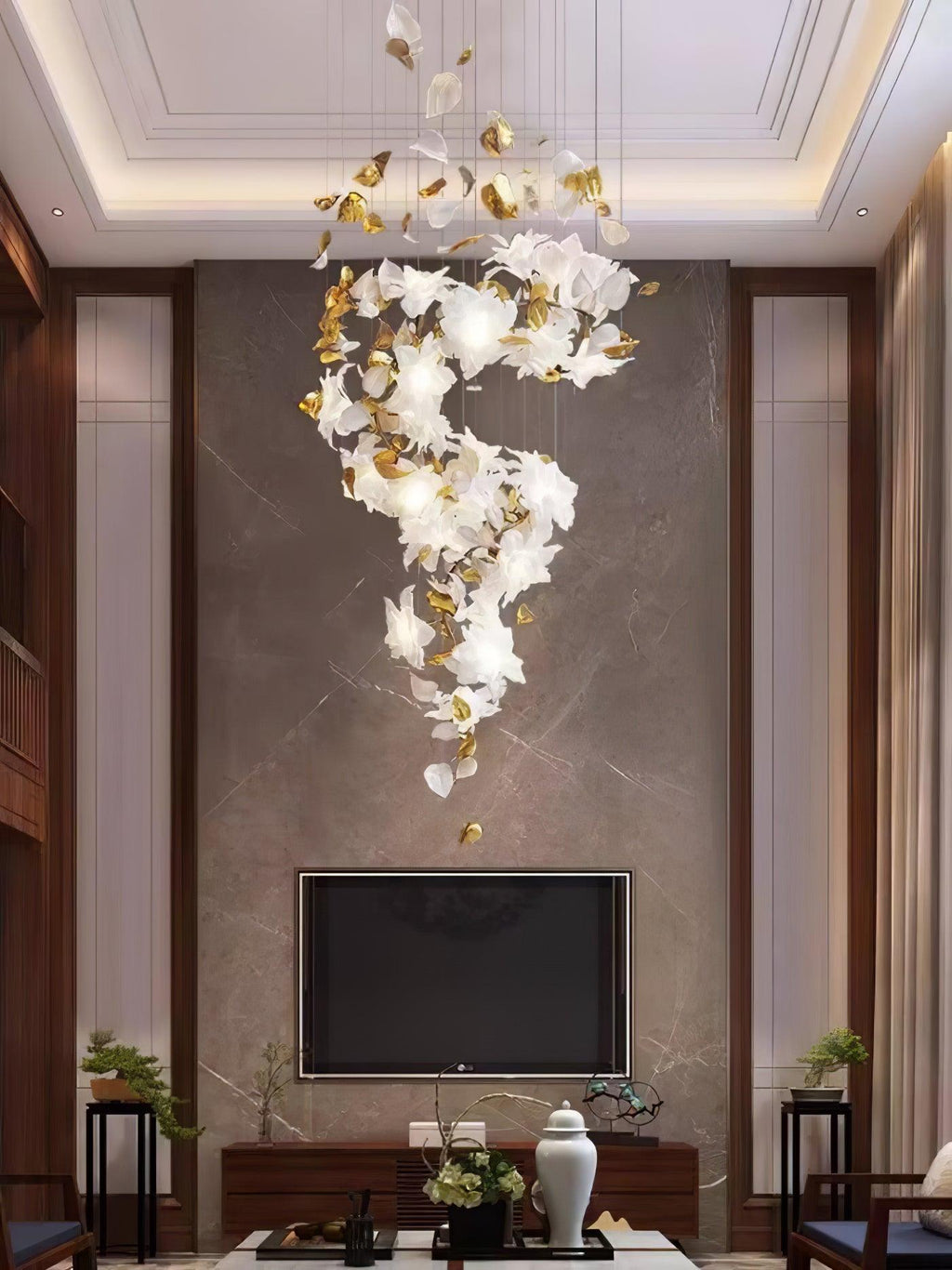 Reaching down a stone-clad wall above a sideboard and television, this Clérachic chandelier hangs in a soft S of petals and gold leaves.