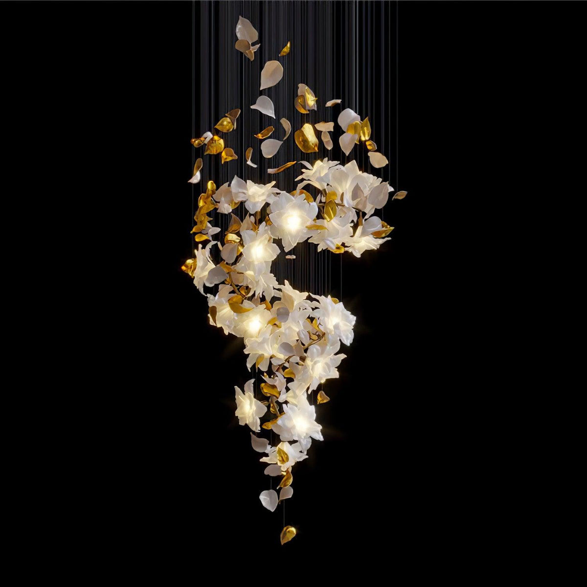 On a black backdrop, this Clérachic chandelier shows its lit white petals and brass leaves twisting down from a curtain of fine cords.