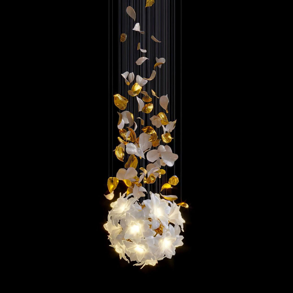 Against black, this Clérachic chandelier glows as a round ball of white petals, with brass leaves scattered on the cords above it.