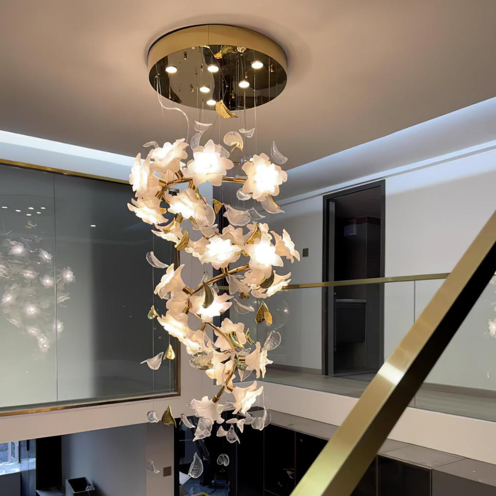 Beneath a round brass ceiling canopy, this Clérachic chandelier hangs through a two-storey room, its white petal flowers softly lit.