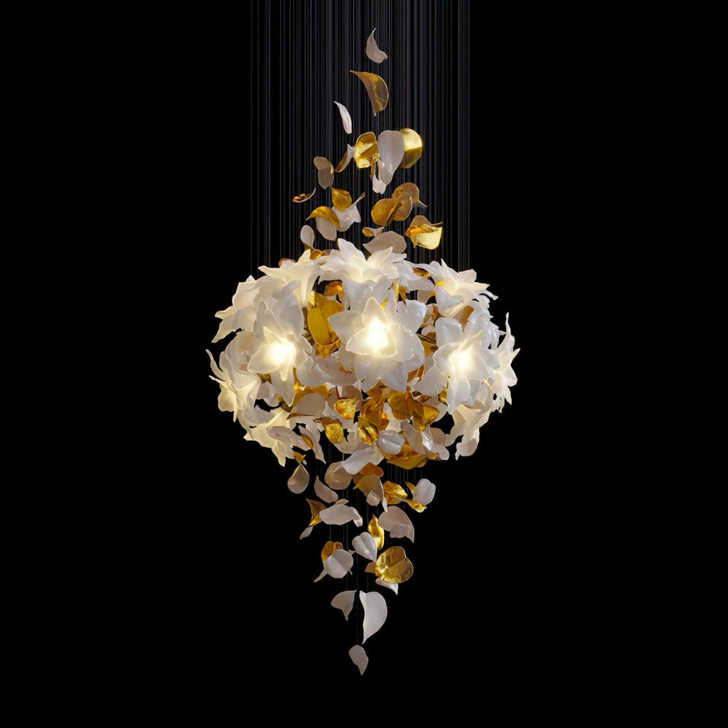 On a black backdrop, a lit Clérachic chandelier shows a full round bloom of white petals with brass leaves hanging below it.