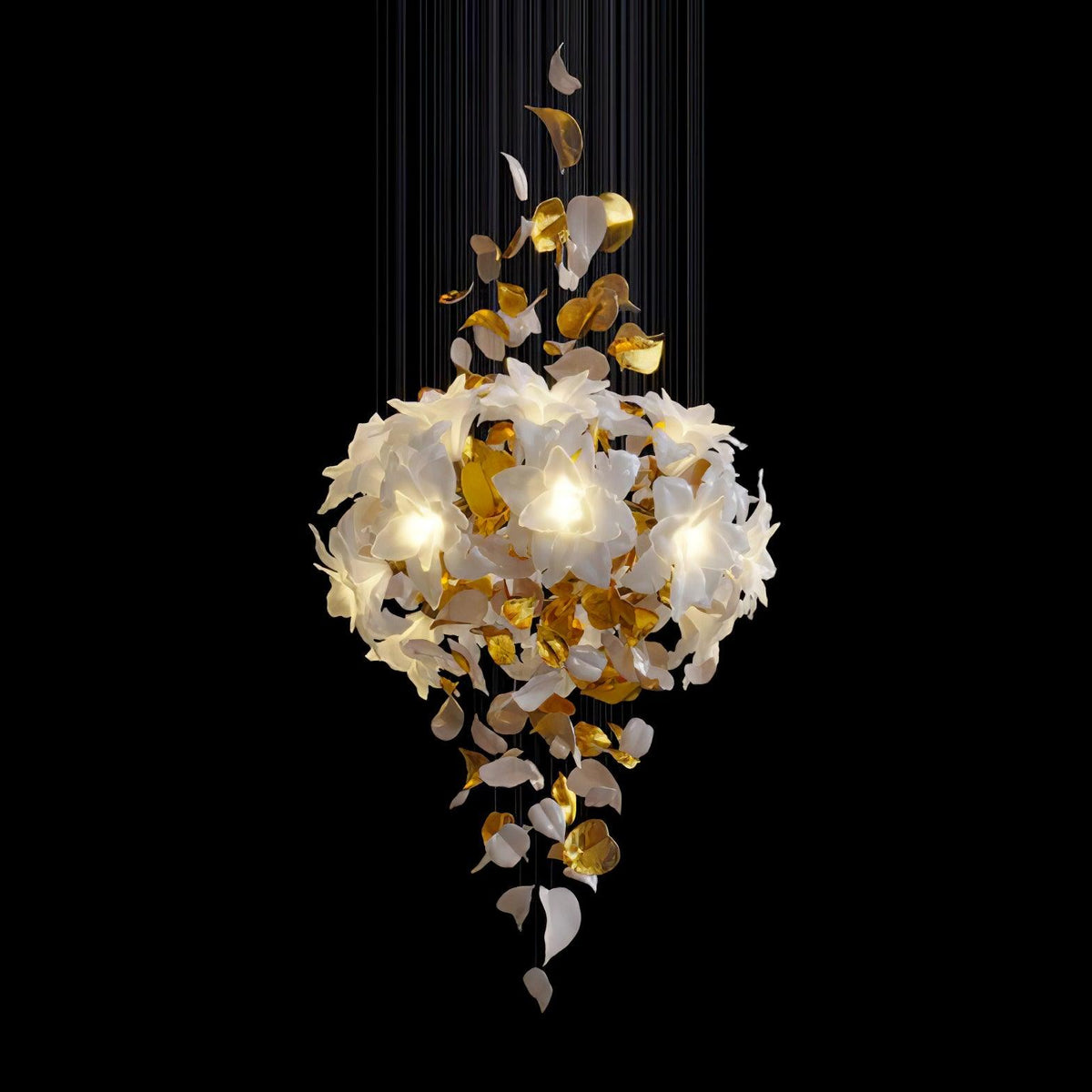 On a black backdrop, a lit Clérachic chandelier shows a full round bloom of white petals with brass leaves hanging below it.