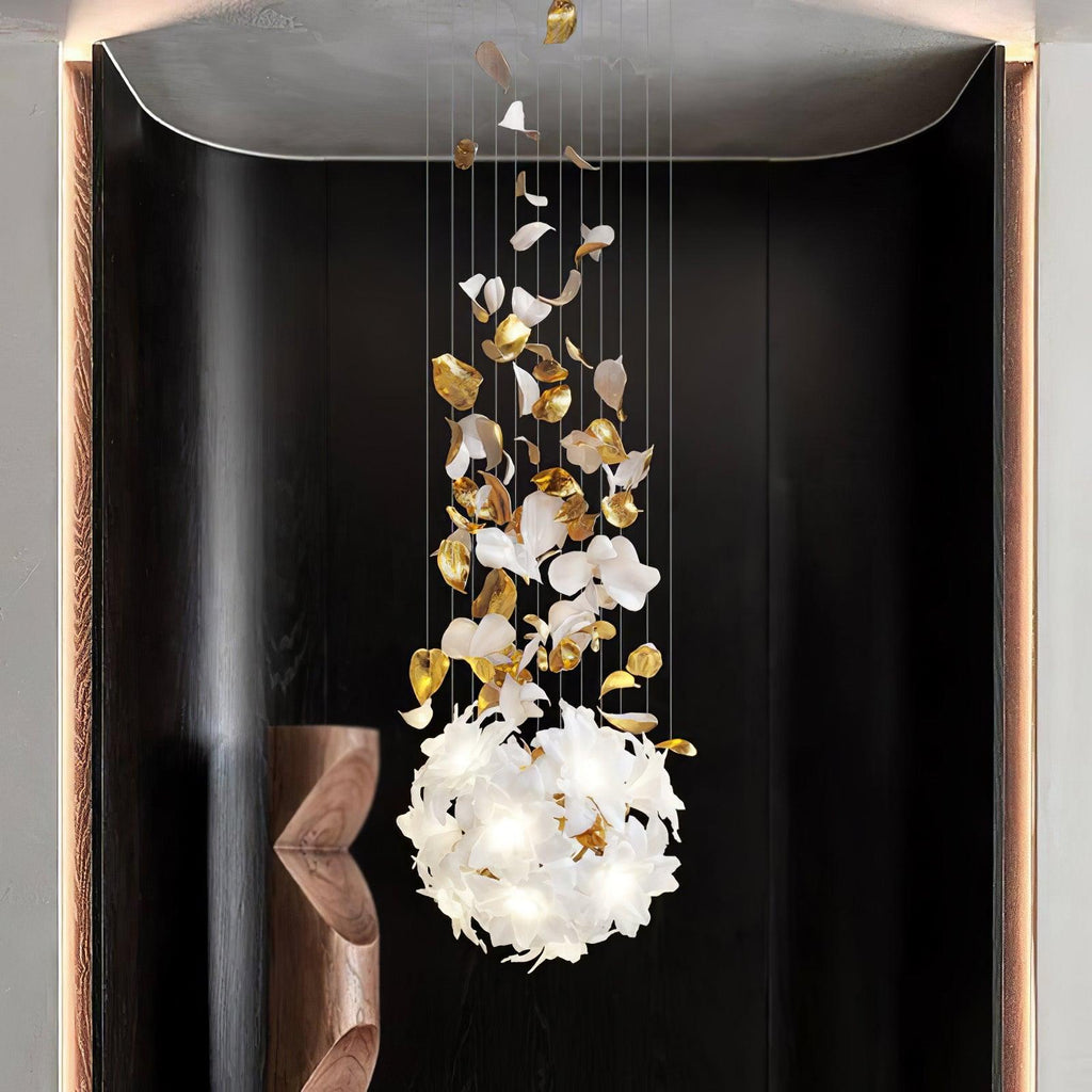 Framed in a dark recess beside a walnut sculpture, this Clérachic chandelier ends in a round ball of white petals with brass leaves above.
