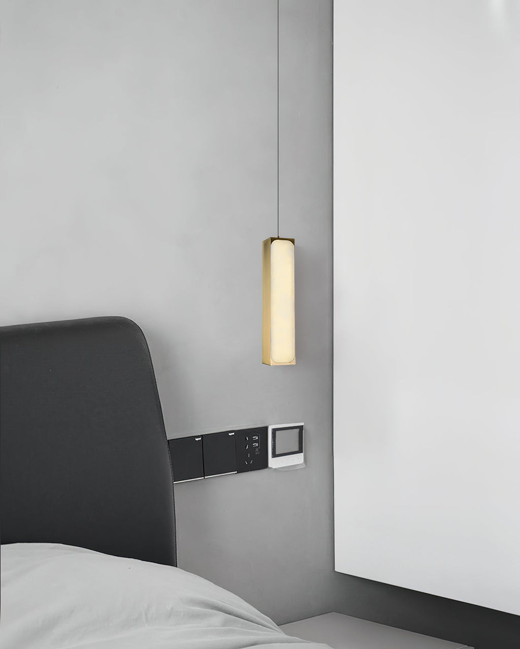 The Clérachic Gleam pendant dropped close to a headboard, its brass column reading as a slender sculpture.