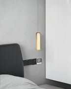 The Clérachic Gleam pendant dropped close to a headboard, its brass column reading as a slender sculpture.